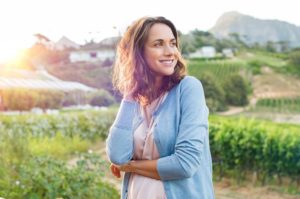a woman outside smiling | How Can My Oral Hygiene Affect My Overall Health?